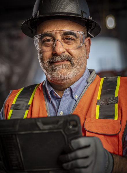 man with protective clothing holding a tablet