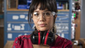 Woman with protective goggles and ear protectors in a wood shop