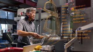 Man working with CNC machinery with wireframe overlay