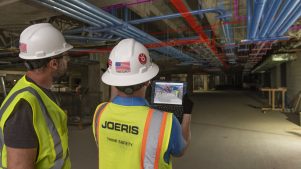 construction workers looking at tablet in facility
