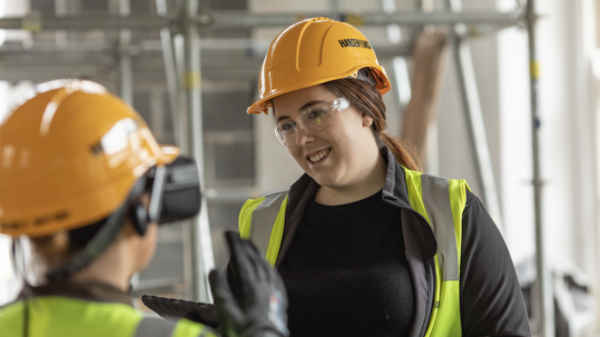 Two women in protective clothing on a construction site