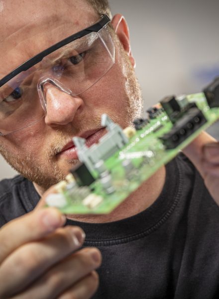 A man inspecting a circuit board