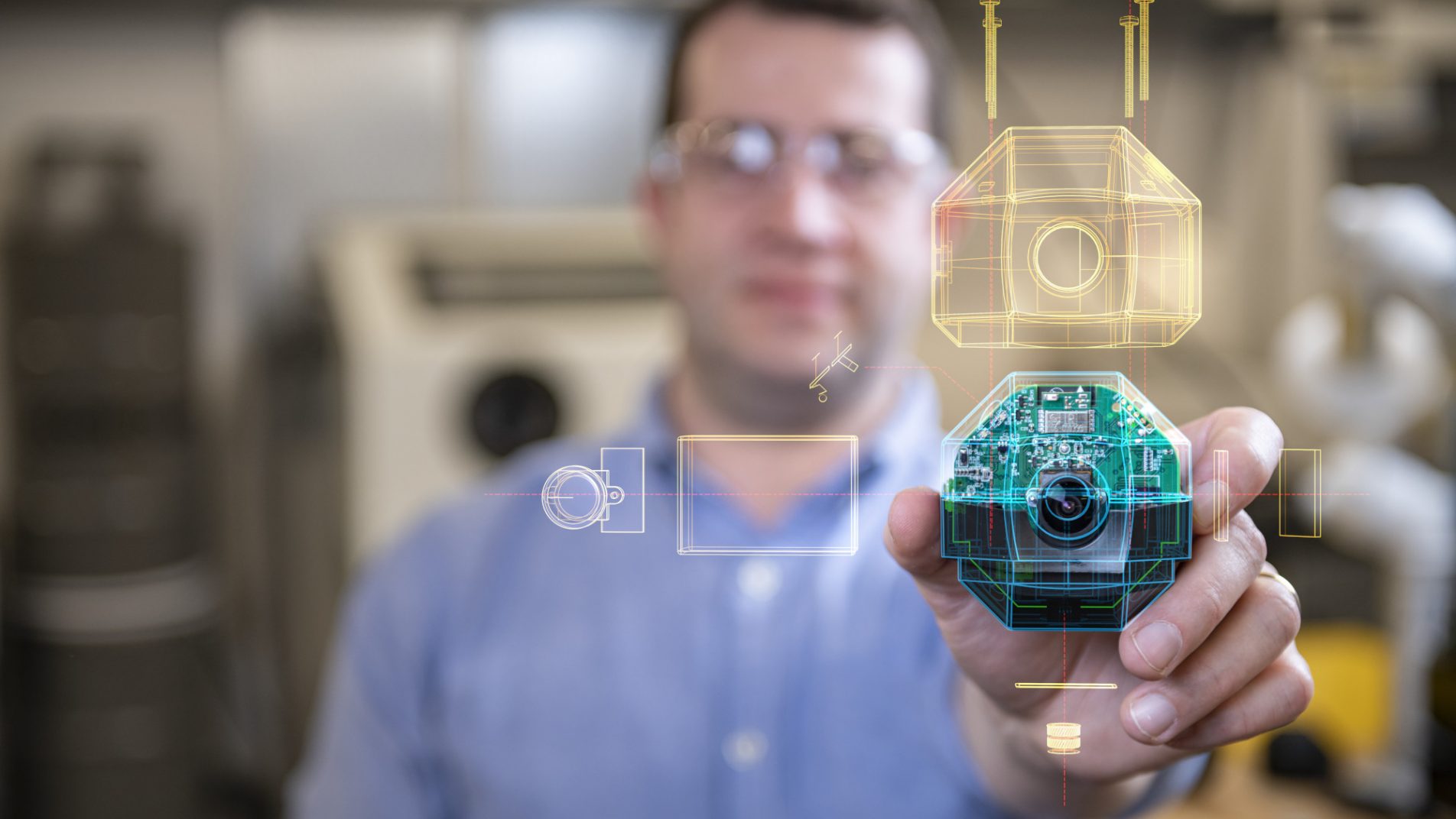 Man with protective goggle hodling a camera with circuits visible and an overlay of the product on top of the imate