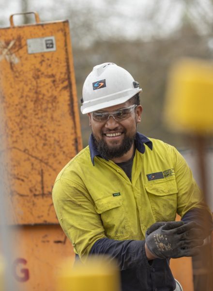 A construction working working in the open and smiling