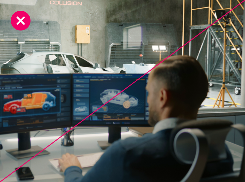 In an automotive lab, a professional analyzes vehicle impact diagrams on his computer, with a wrecked car in the background and industrial equipment surrounding the space, making it unclear what the focal point of the image is supposed to be. Marked with a red X.