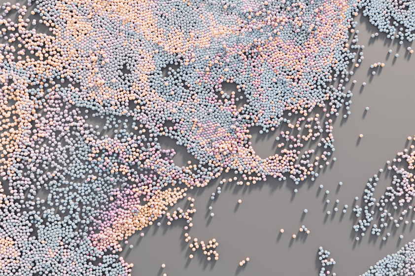 Thousands of small pastel-colored orbs (pink, blue, and peach) scatter across a gray surface, forming abstract patterns.